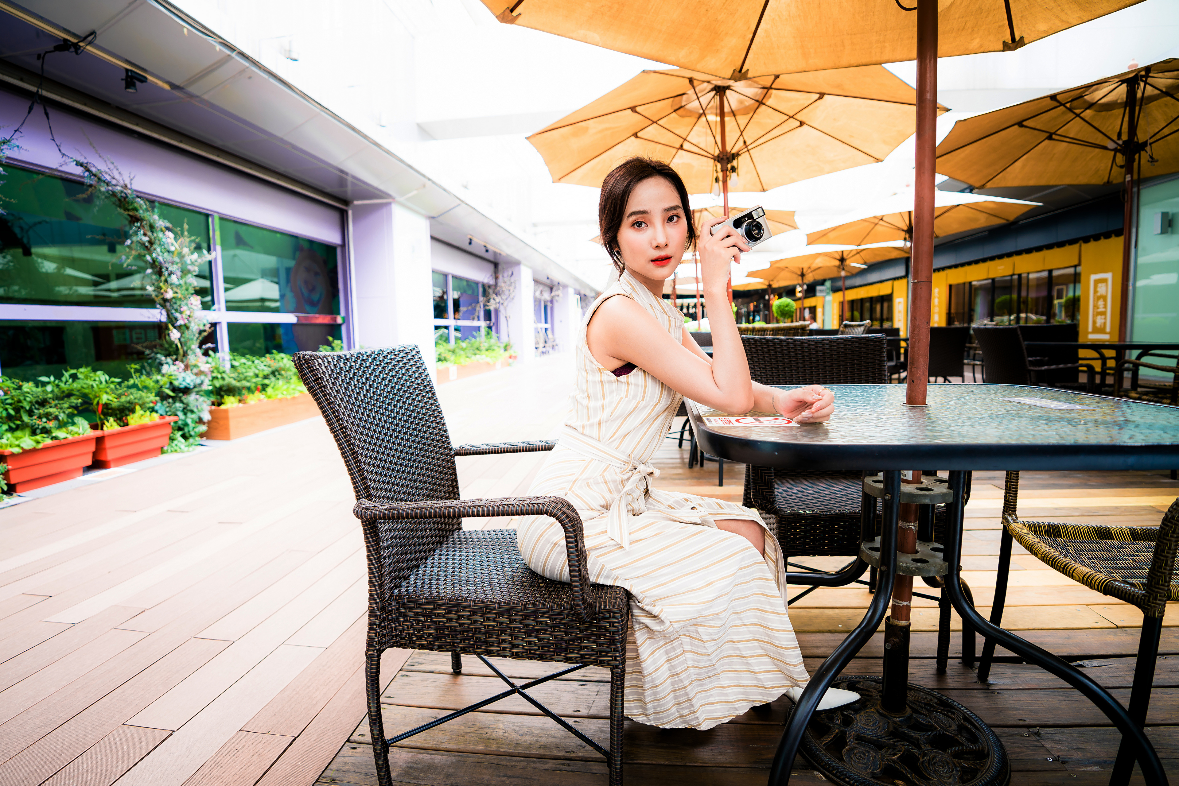 Asian Model Women Long Hair Brunette Table Chair Umbrella Plant Pot Plants Camera Dress White Shoes  3840x2561