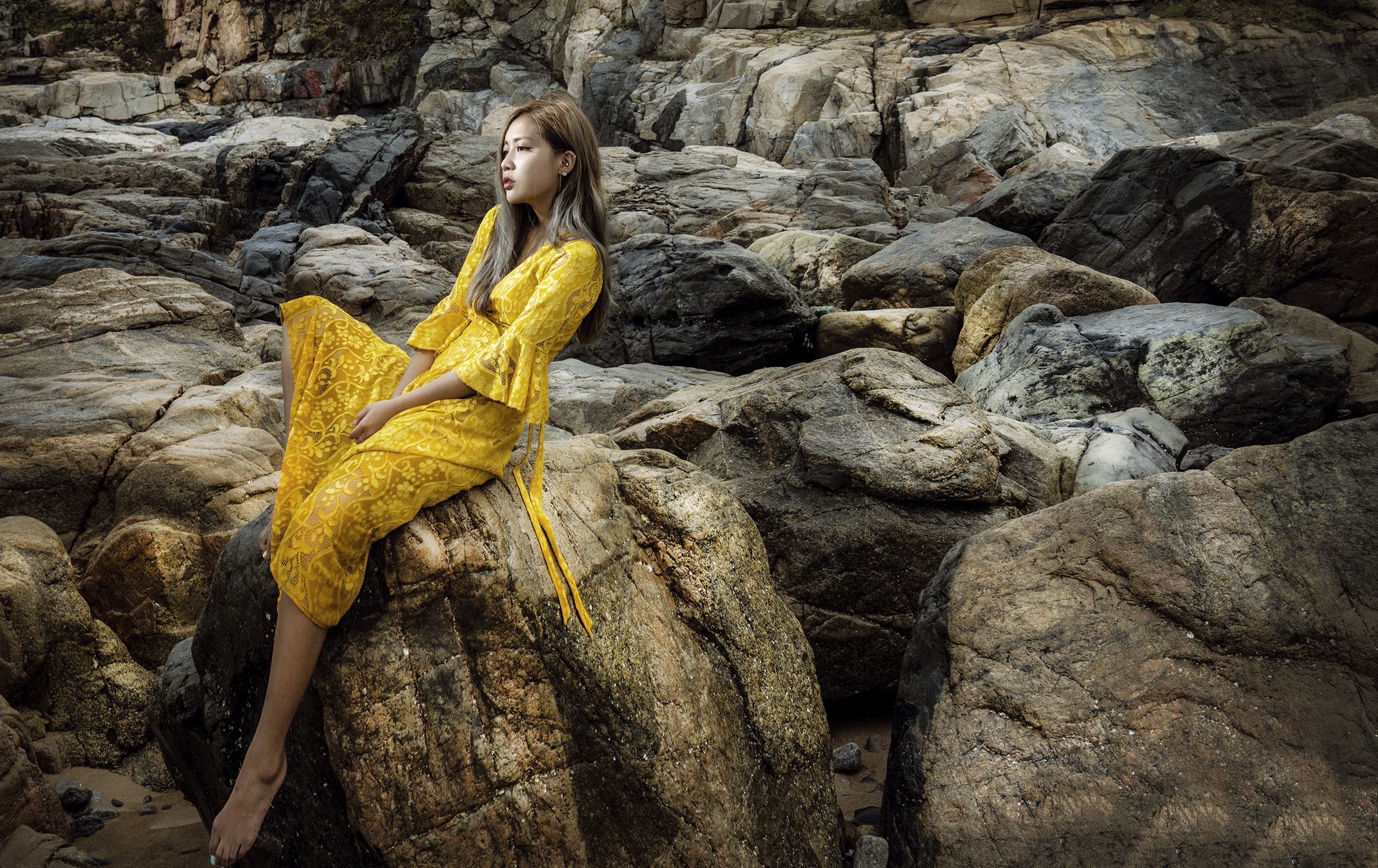 Asian Model Women Long Hair Yellow Dress Sitting Rocks Earring Brunette Looking Into The Distance 2400x1512