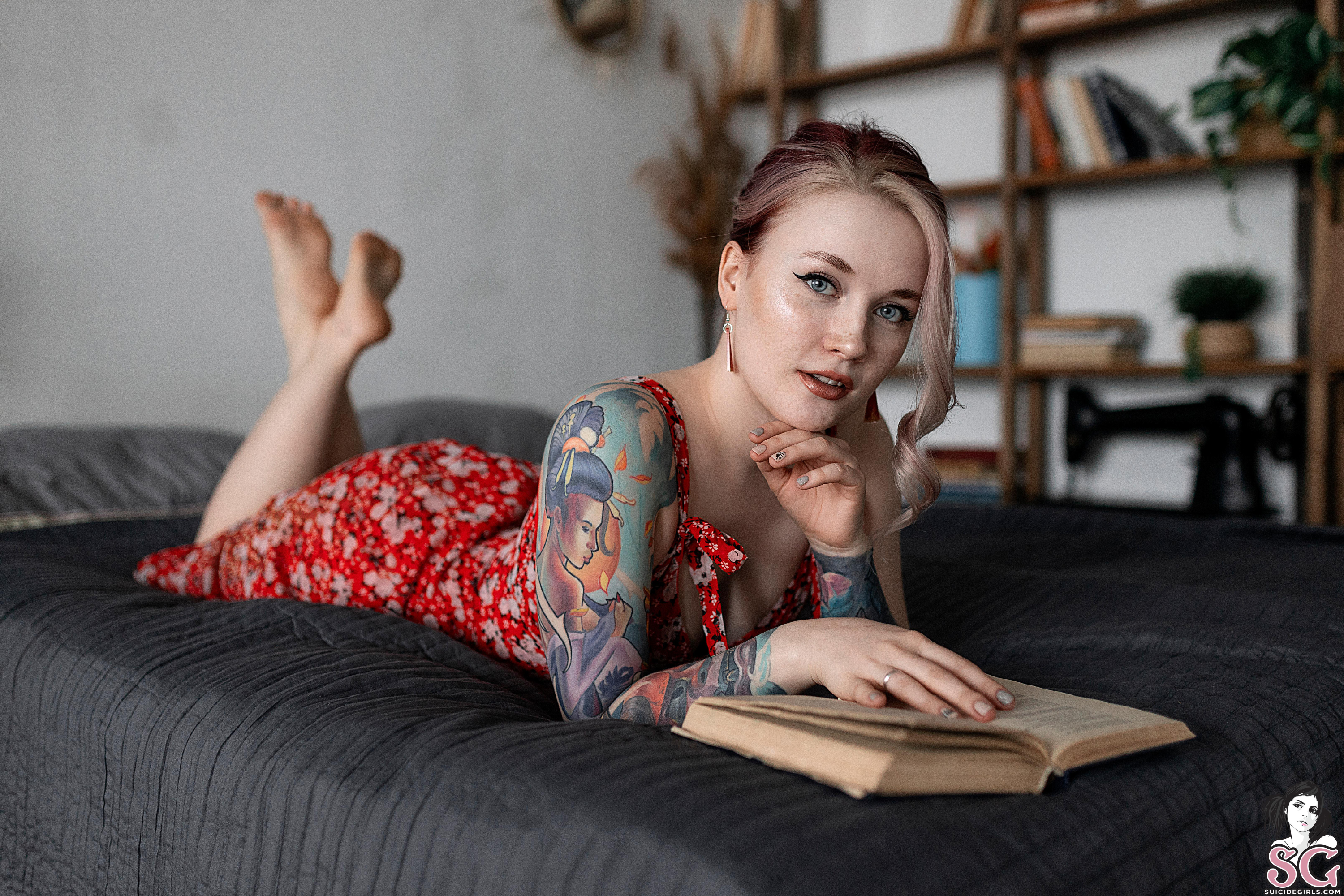 Watermarked Women Dyed Hair Tattoo Lying On Front Painted Nails Dress Bed In Bed Reading 3000x2000