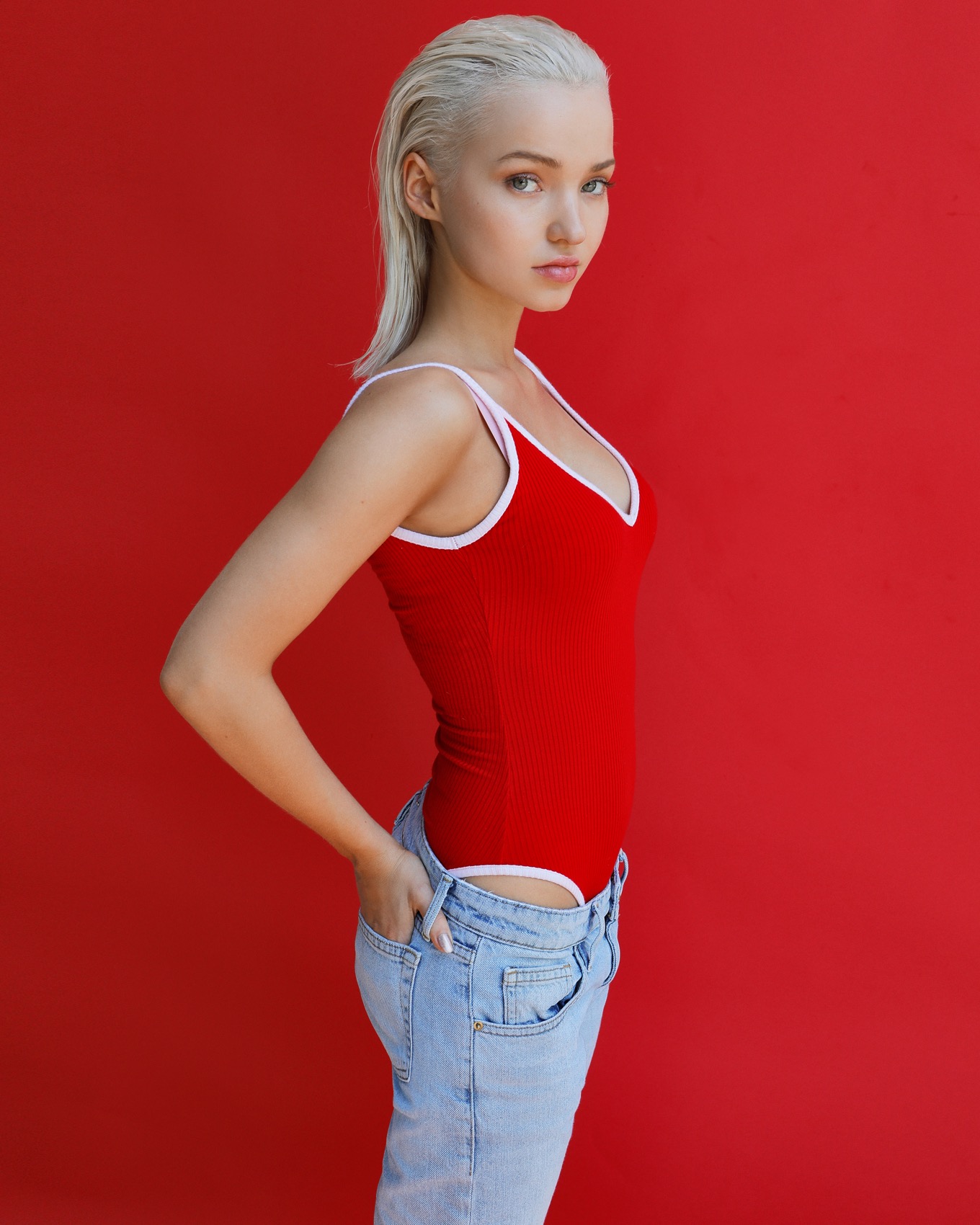 Dove Cameron Women Actress Singer Blonde Green Eyes Jeans Hands In Pockets Red Red Background Profil 1360x1700